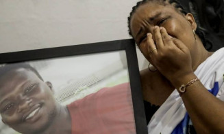 Mãe de Moise com a foto do filho brutalmente assassinado