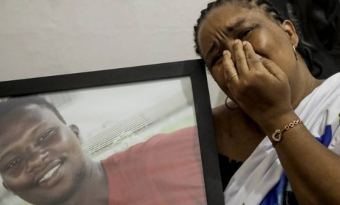 Mãe de Moise com a foto do filho brutalmente assassinado